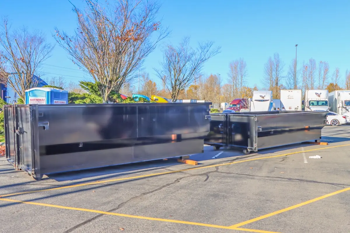 Professional dumpster rental service with roll-off container on residential driveway in Pineville